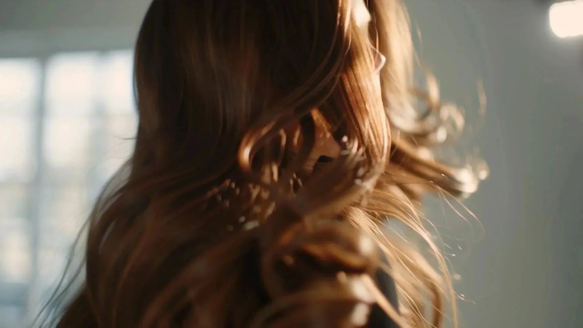 Close-up of healthy, shiny hair flowing in soft motion under natural light, showcasing smooth, nourished results from Arove Beauty haircare.