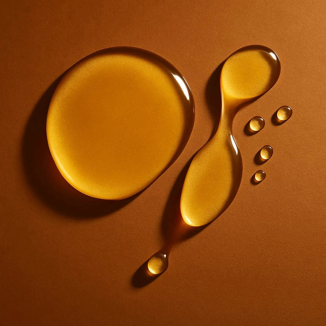 Golden drops of nourishing hair oil on a warm background, highlighting Arove Beauty’s lightweight shine-boosting formula for smooth, hydrated hair.