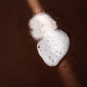 Arove Aerious Shampoo—white cleansing powder and rich foamy lather on a dark brown background