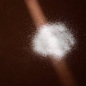 Arove Aerious Waterless Conditioner—white powder swatch on a dark brown background
