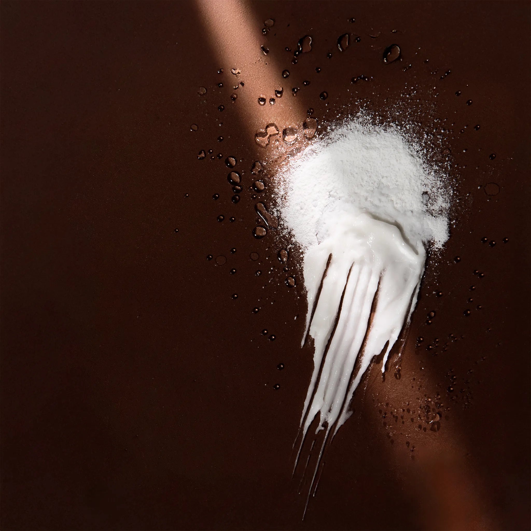 Arove Aerious Waterless Conditioner—powder transforming into creamy texture on a dark brown background