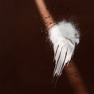 Arove Aerious Waterless Conditioner—powder transforming into creamy texture on a dark brown background